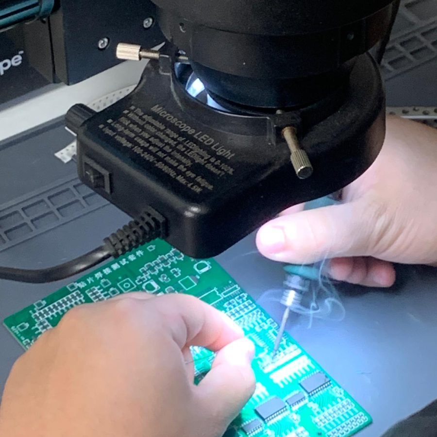 Curso profesional de microsoldadura y reparación de hashboards de ASIC, mostrando manos soldando bajo microscopio con cautín en equipos de minería